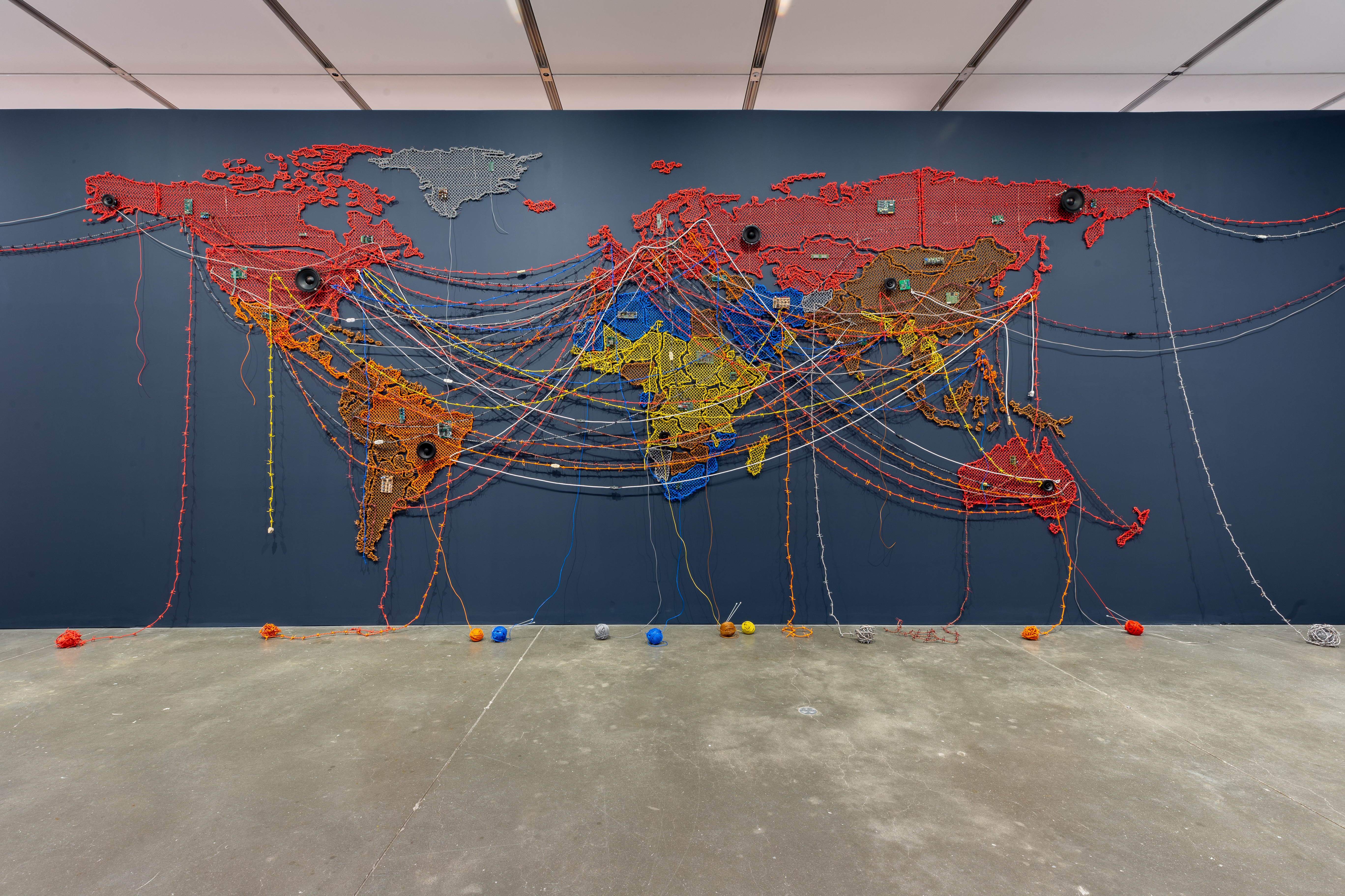 A colorful world map hangs from the wall, with threads linking different countries.