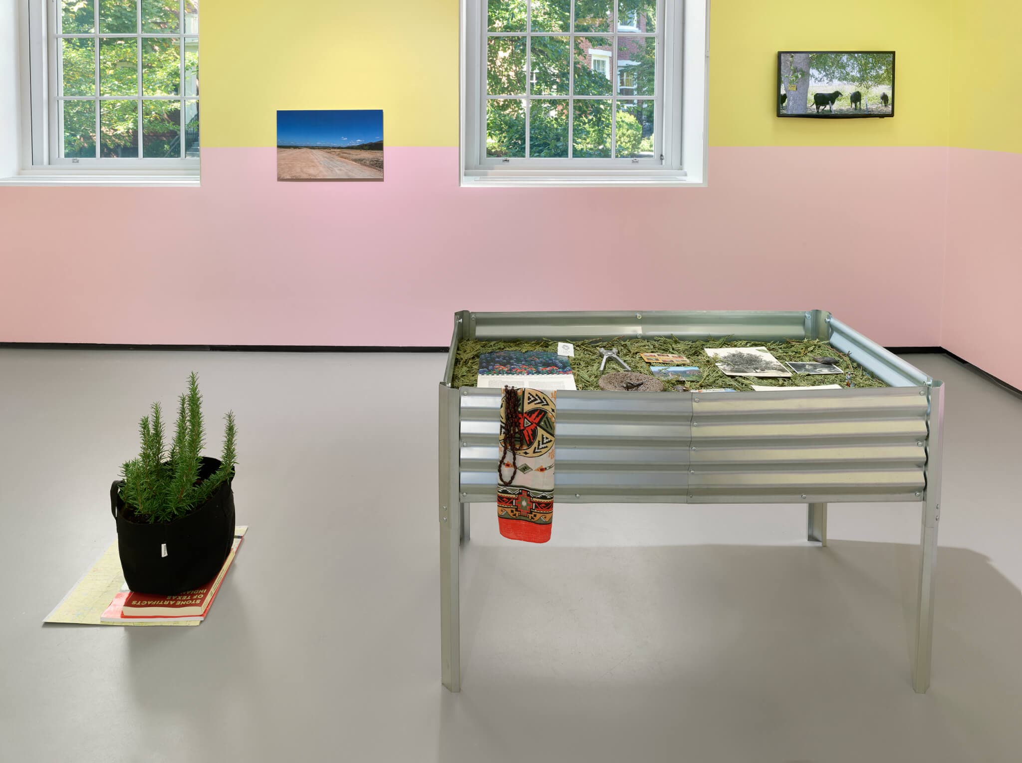A corrugated metal container stands in the center of a gallery space.