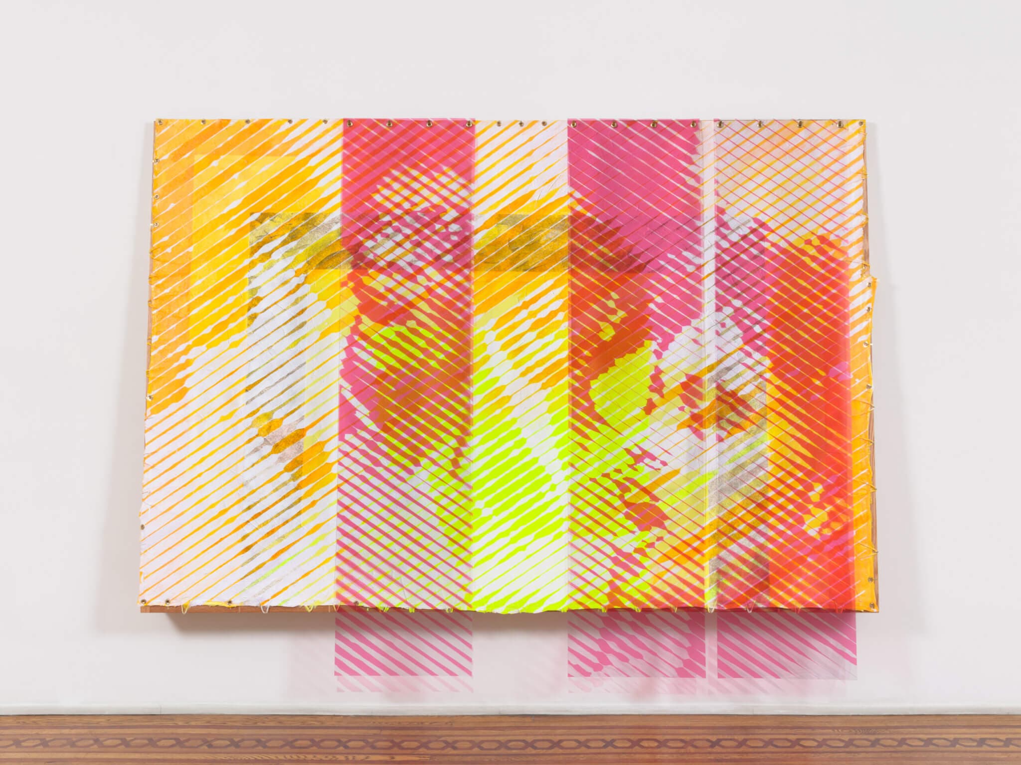 An installation view of a painting on a white wall. The painting shows four expressive faces beneath red and orange alternating stripes.